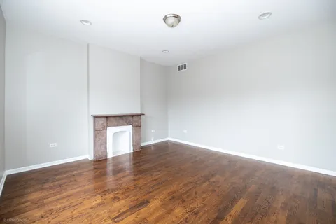 a view of empty room with wooden floor and fireplace