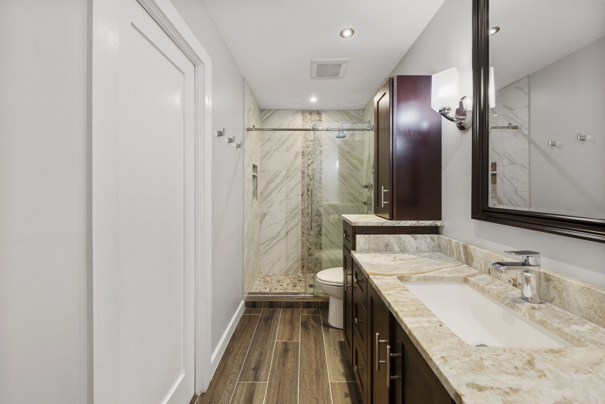 801 River Road, Unit 105C Montgomery, TX 77356 - Photo 19 of 30 The updated bathroom features a beautifully tiled shower surround with sleek sliding glass shower doors for a modern finish.