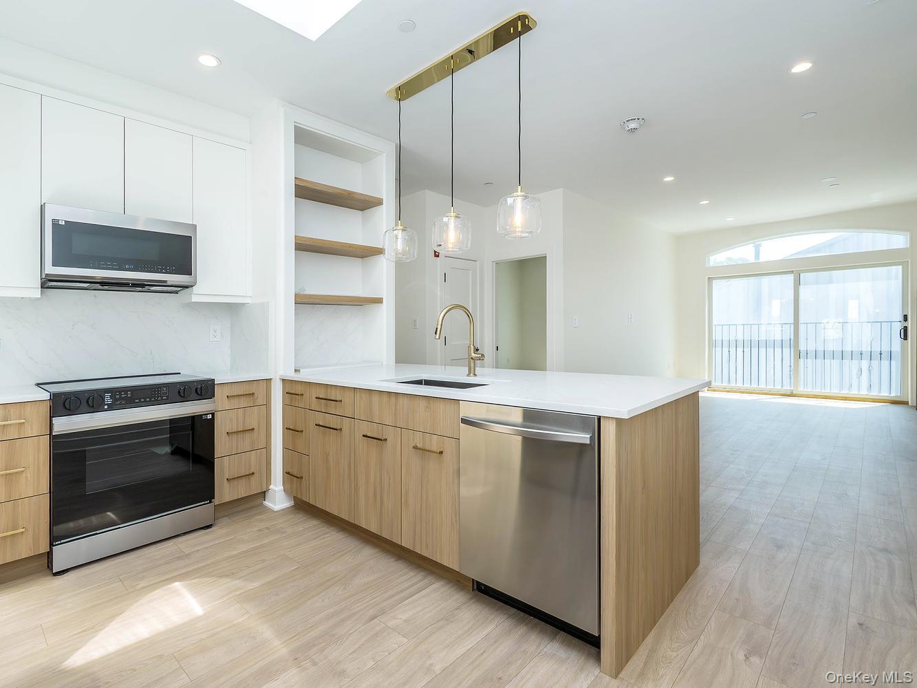 24 Lumber Road, Unit 2 Roslyn, NY 11576 - Photo 4 of 25 a open kitchen with stainless steel appliances granite countertop a stove a sink and a microwave