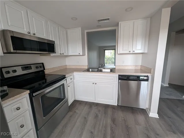 a kitchen with a sink stove and microwave