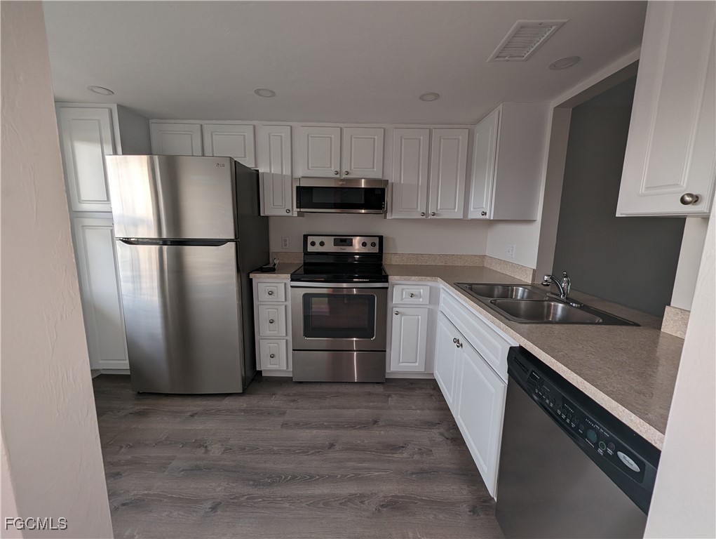 1519 Cape Coral Parkway West, Unit 8 Cape Coral, FL 33914 - Photo 3 of 19 a kitchen with a refrigerator sink and cabinets