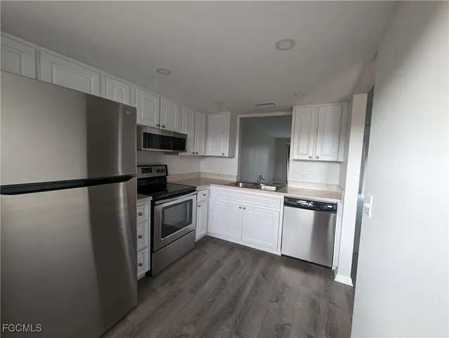 a kitchen with a refrigerator stove and wooden cabinets