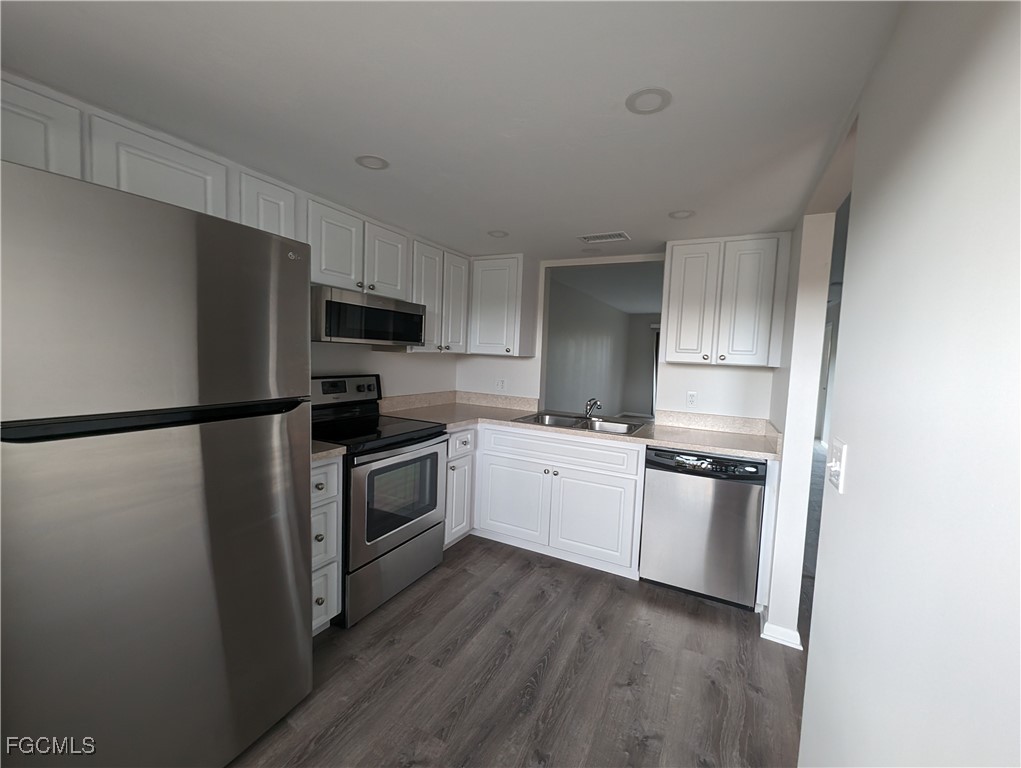 1519 Cape Coral Parkway West, Unit 8 Cape Coral, FL 33914 - Photo 4 of 19 a kitchen with a refrigerator stove and wooden cabinets