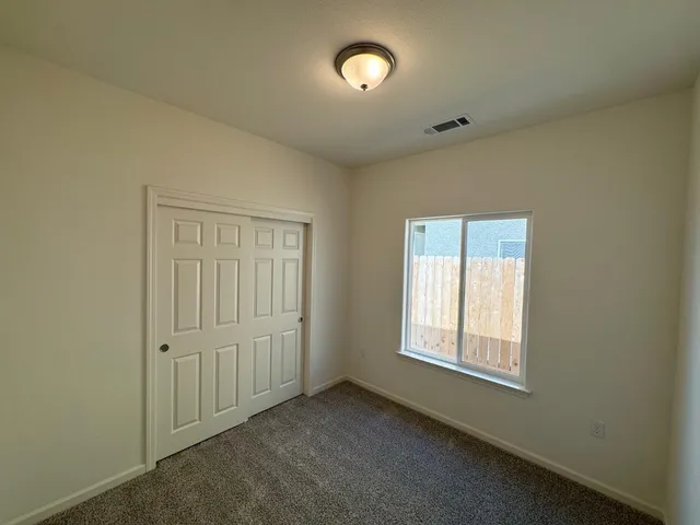 an empty room with a window and a fan
