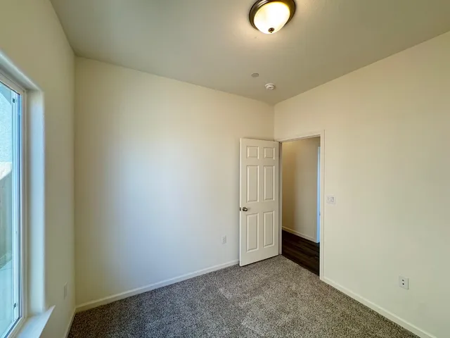 an empty room with a ceiling fan and a window