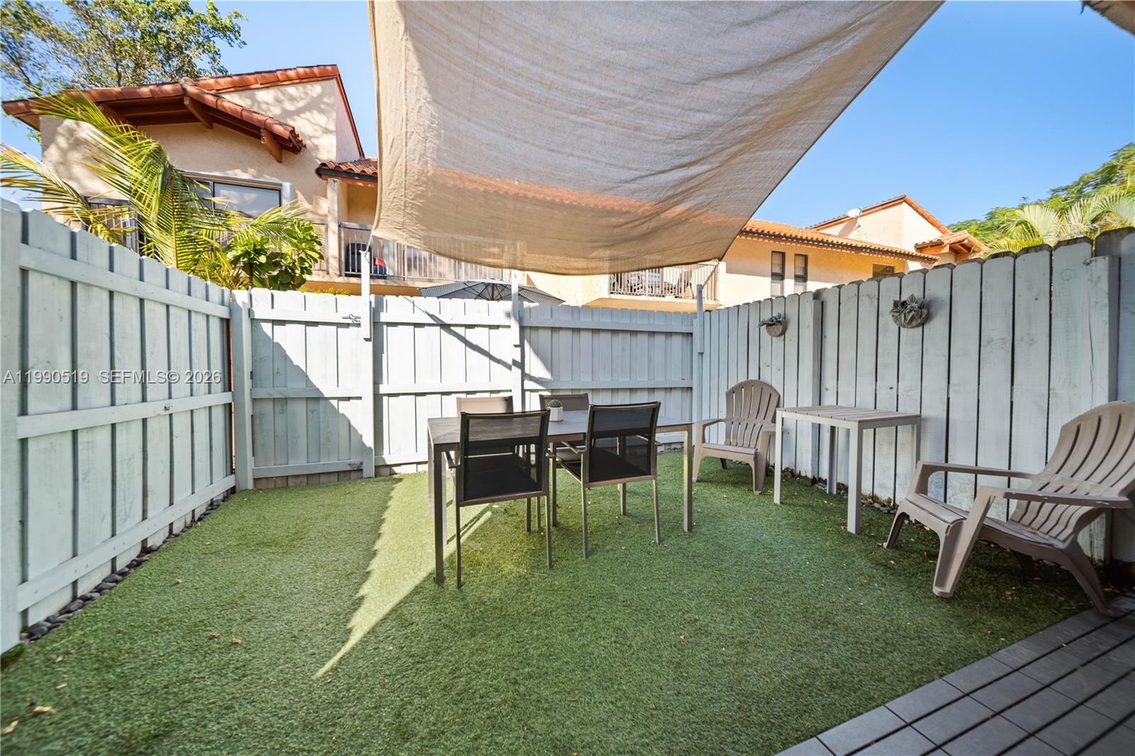10206 Southwest 77th Court Miami, FL 33156 - Photo 10 of 28 a view of a backyard with table and chairs with wooden fence