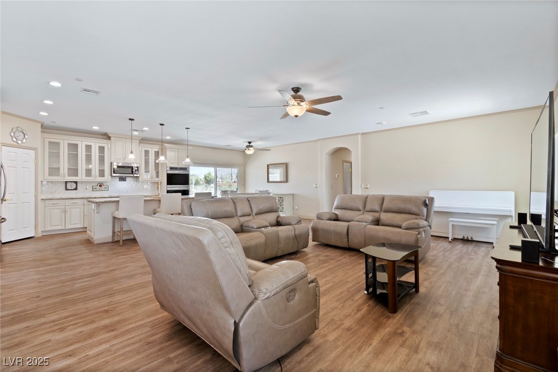 5315 North Fort Apache Road Las Vegas, NV 89149 - Photo 46 of 46 Open Floor Plan with a total 744 SF Living and Dining area with ceiling fans, Luxury Vinyl Plank flooring, recessed lighting, and an arched hallway.