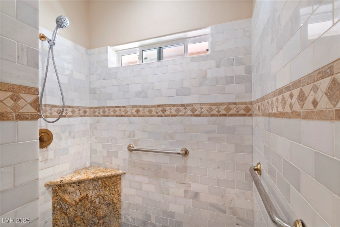 5315 North Fort Apache Road Las Vegas, NV 89149 - Photo 32 of 46 Full walk in bath featuring tiled shower and tiled shelf with safety bars.