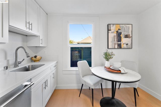 a kitchen with stainless steel appliances granite countertop a refrigerator sink and white cabinets