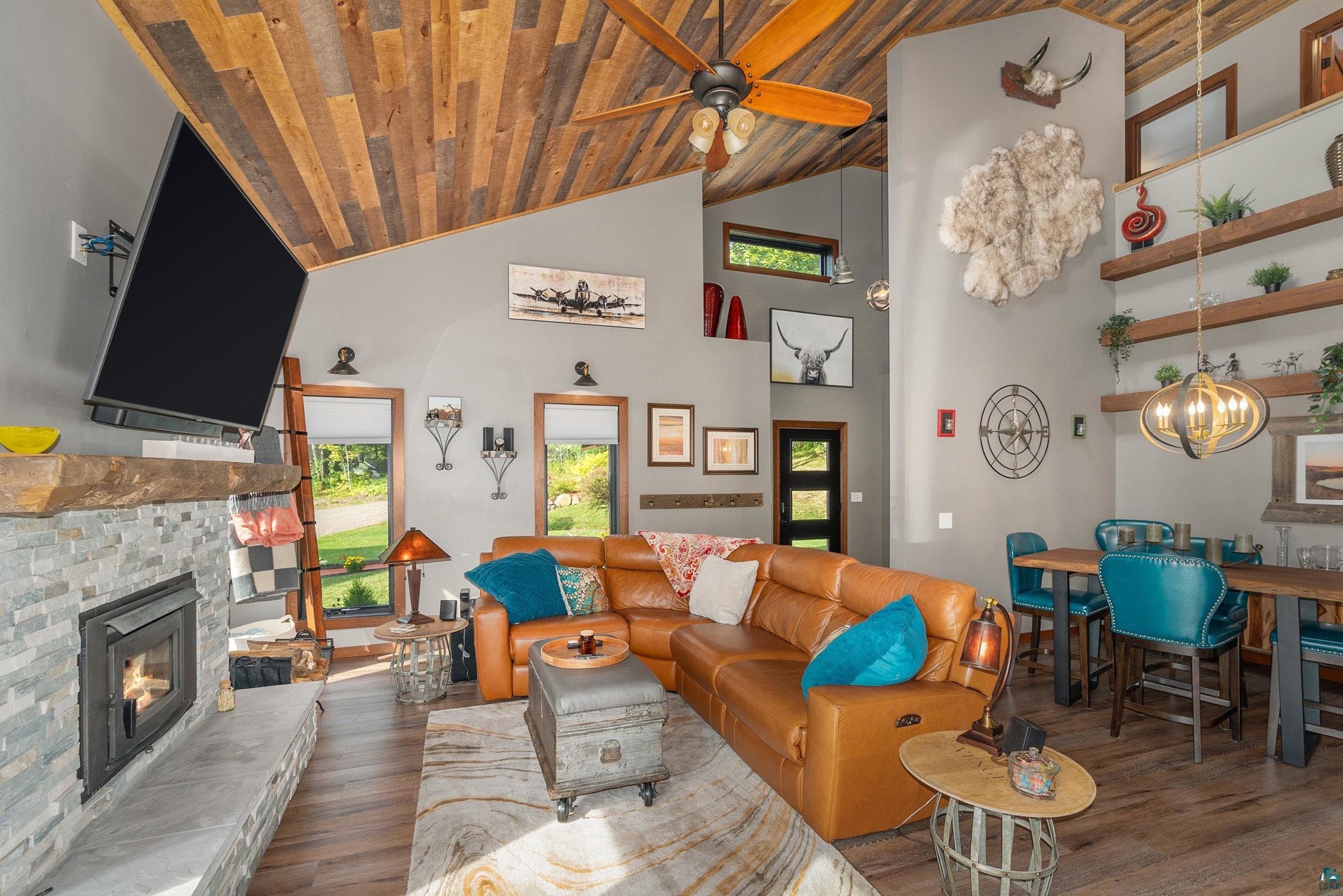 5196 Eagle Lake Road Duluth, MN 55803 - Photo 8 of 50 Living room featuring ceiling fan with notable chandelier, a fireplace, wood ceiling, and wood-type flooring