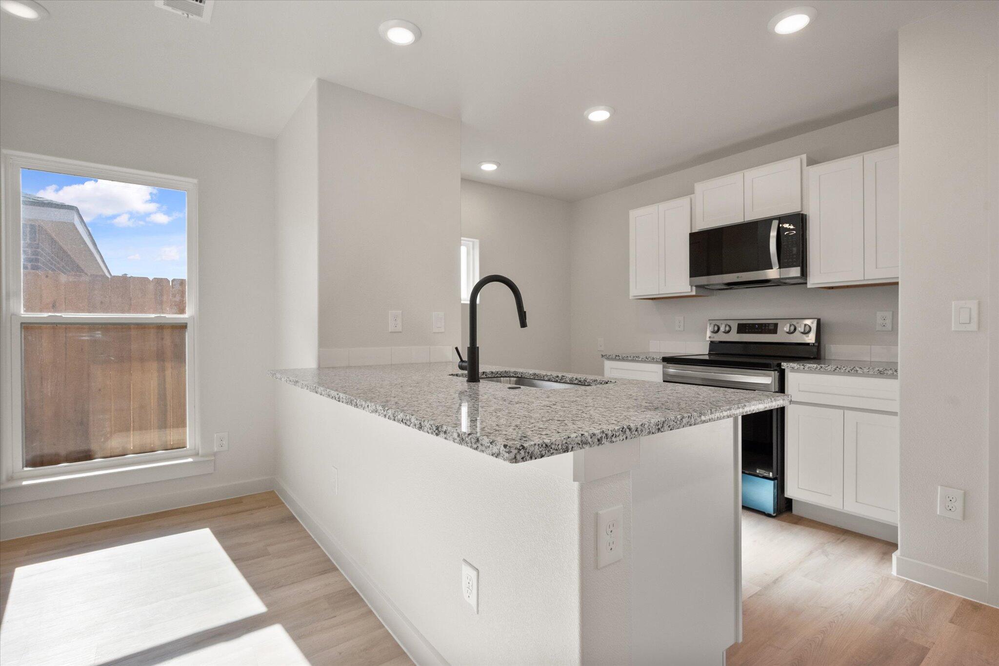 1603 North Clinton Avenue Lubbock, TX 79416 - Photo 5 of 14 a kitchen with granite countertop a sink and a stove top oven