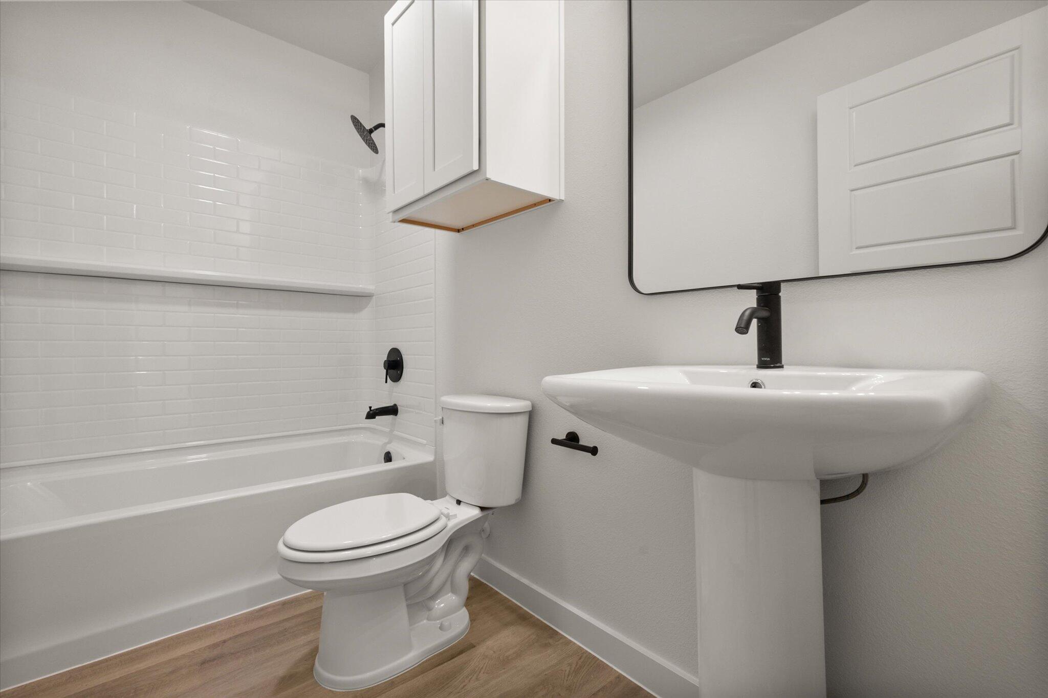 1603 North Clinton Avenue Lubbock, TX 79416 - Photo 7 of 14 a bathroom with a toilet sink a mirror and bathtub