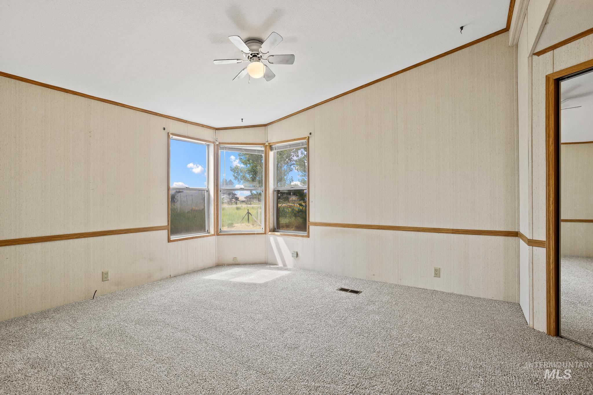 3680 South Mill Road Emmett, ID 83617 - Photo 26 of 38 Bright interior space with light-toned carpeting and a ceiling fan with integrated lighting