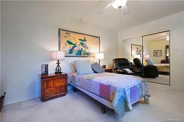 a spacious bedroom with a bed a couch and a chandelier