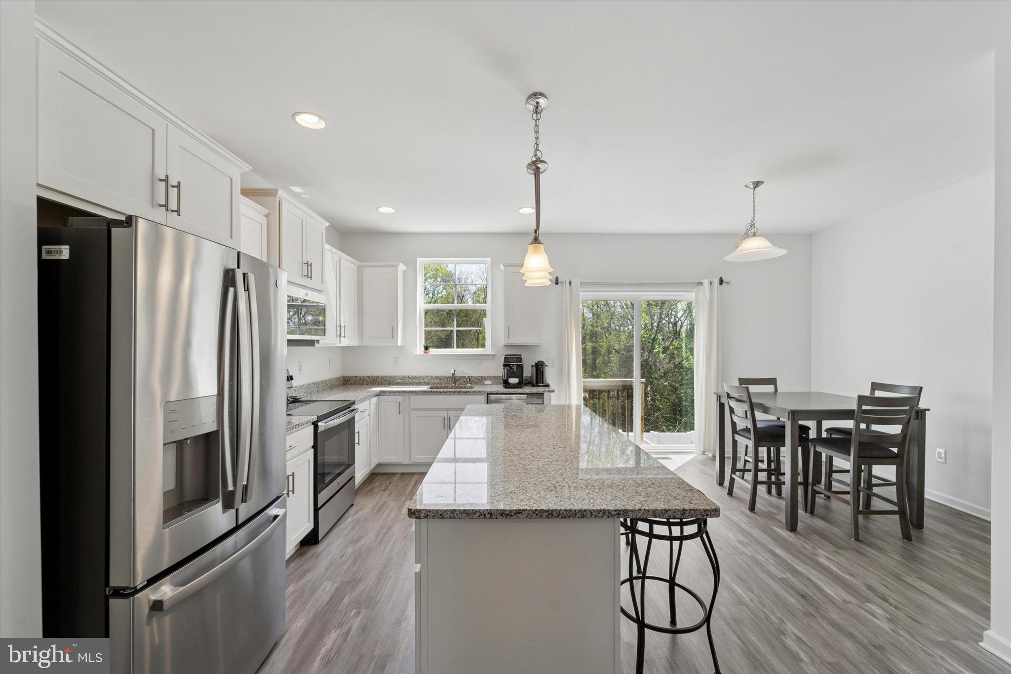 65 Aviary Road Thorofare, NJ 08086 - Photo 6 of 16 a kitchen with stainless steel appliances granite countertop a table chairs stove and refrigerator