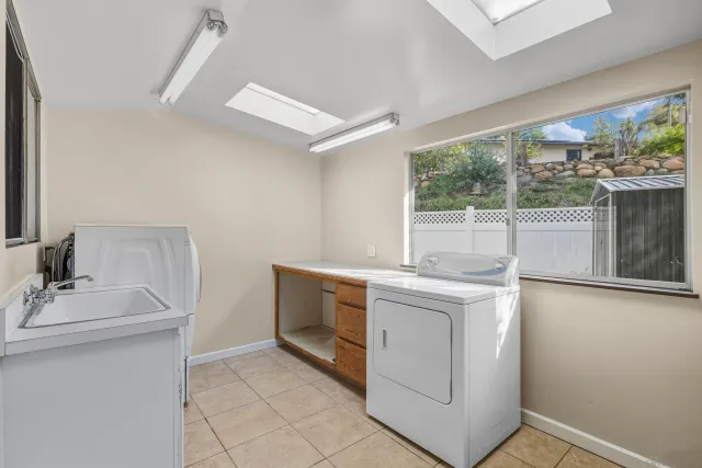 an empty room with windows and chandelier fan