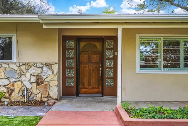 a front view of a house with a yard and green space