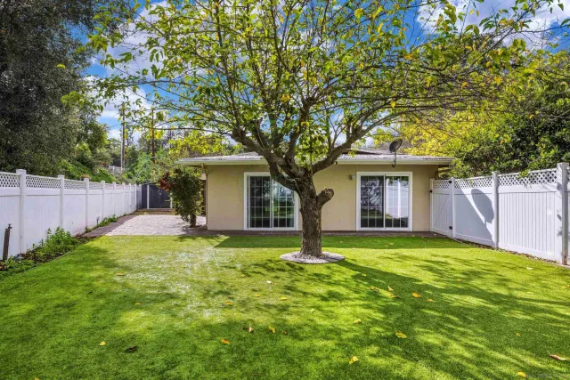 a view of a house with a yard and potted plants