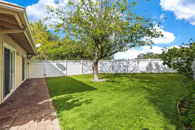 a view of a chair and table in backyard of the house