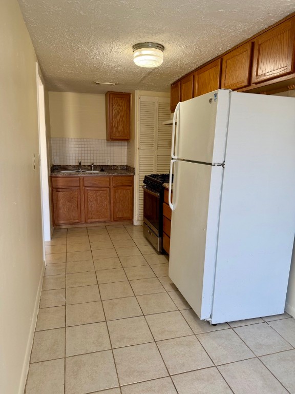 1608 Dyer Avenue Rosenberg, TX 77471 - Photo 5 of 16 a kitchen with a refrigerator and a stove