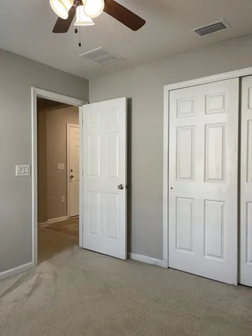 a view of an empty room and a ceiling fan