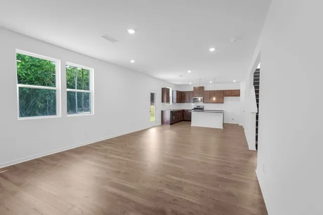 a view of kitchen and hall with wooden floor