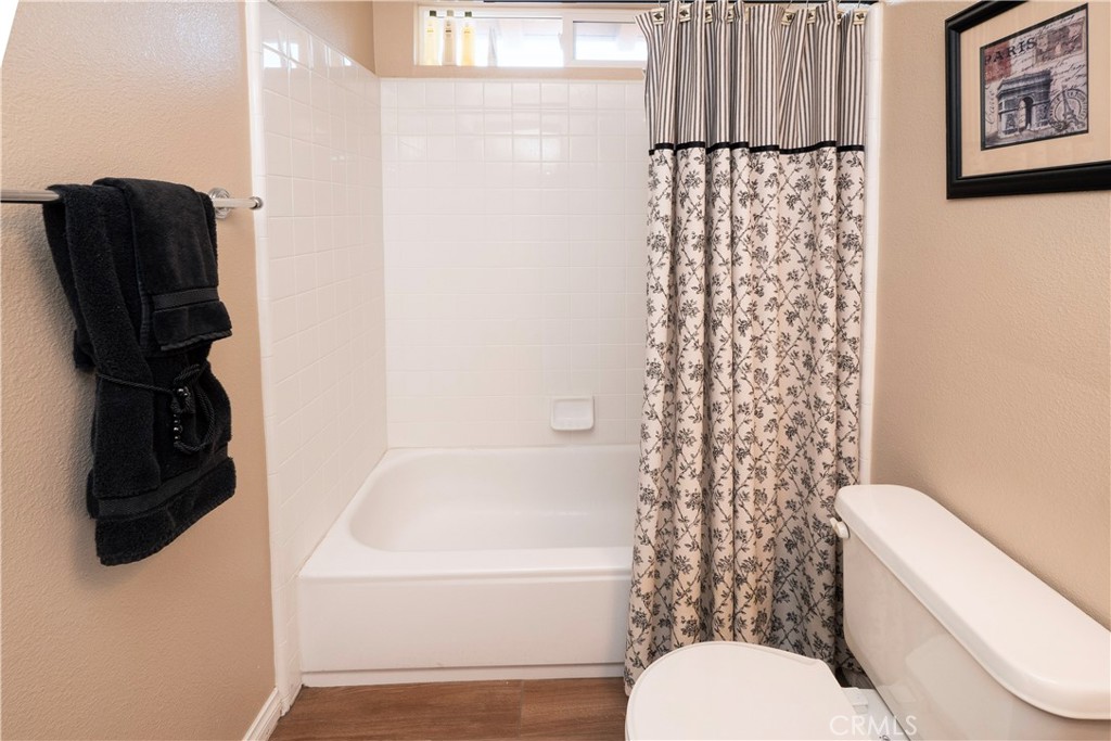 14251 Ashton Lane Riverside, CA 92508 - Photo 40 of 69 a bathroom with a toilet and a shower curtain