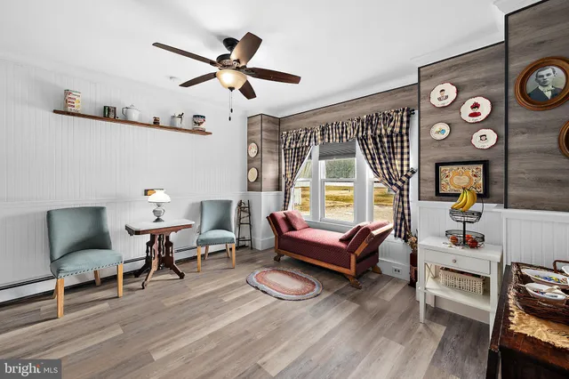 a view of a patio with couches table and chairs under an umbrella with a barbeque