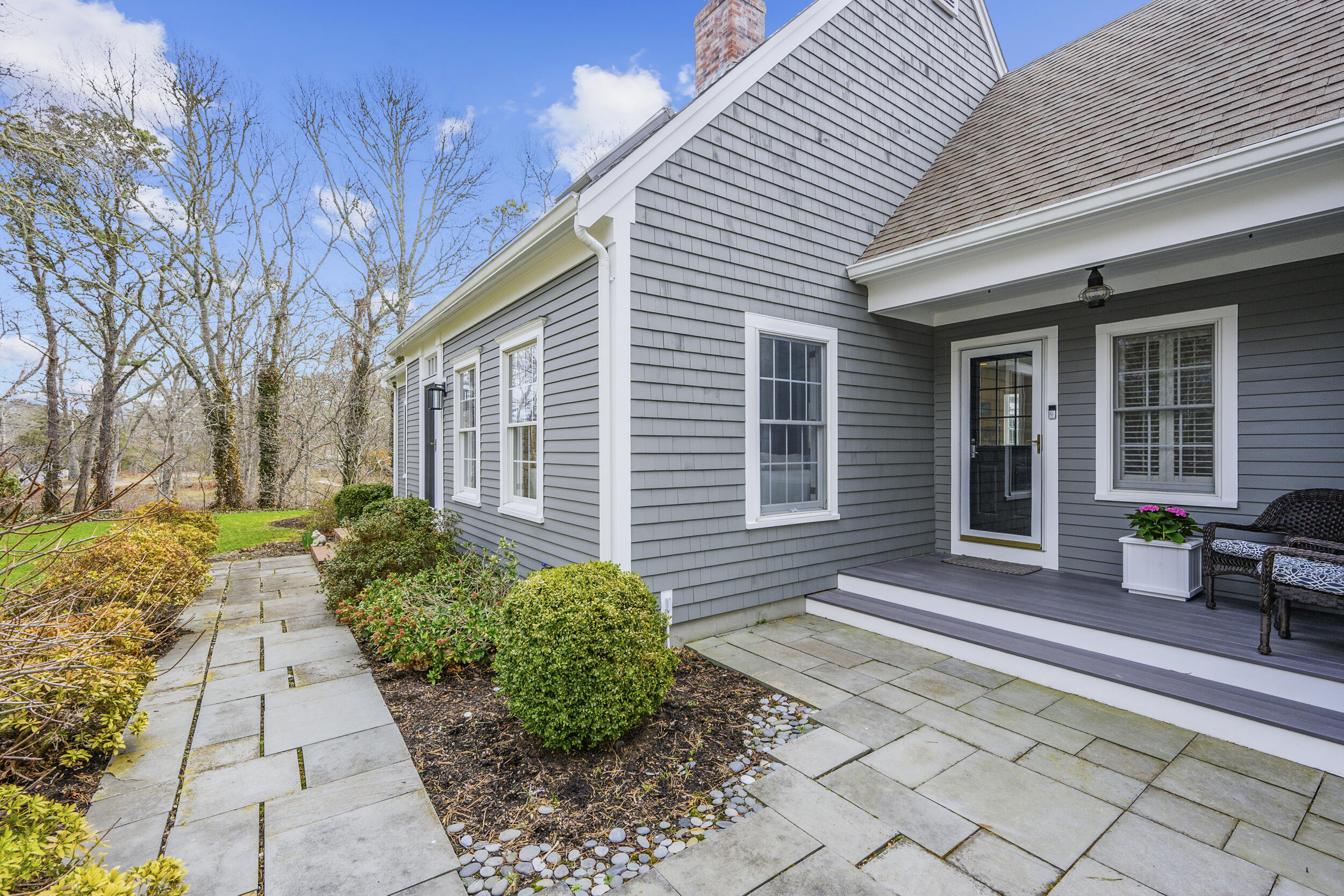 83 Cemetery Road Harwich, MA 02645 - Photo 5 of 53 a front view of a house with a large window and potted plants
