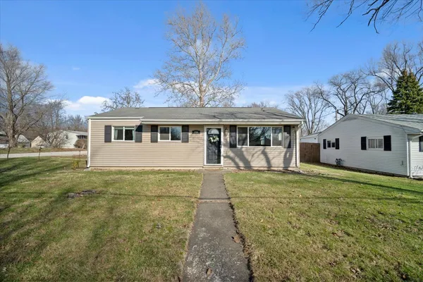 a view of a house with backyard and sitting area