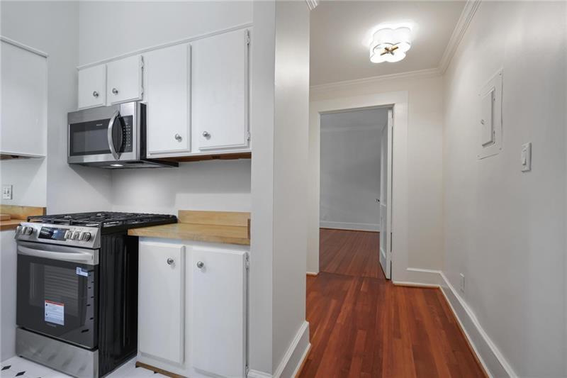 1 South Prado Northeast, Unit 1 Atlanta, GA 30309 - Photo 12 of 21 a kitchen with stainless steel appliances a stove a microwave and cabinets