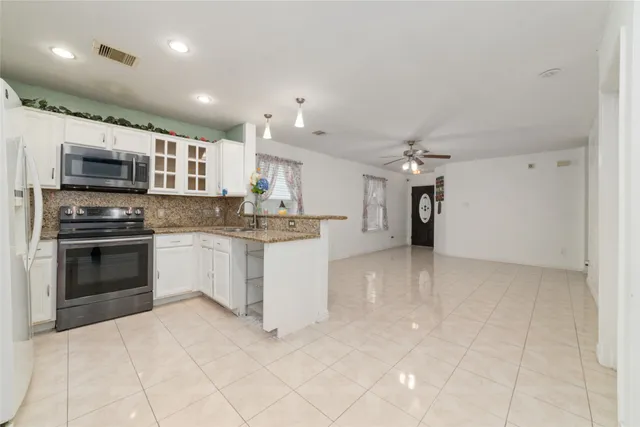 a kitchen with kitchen island granite countertop a stove sink and microwave