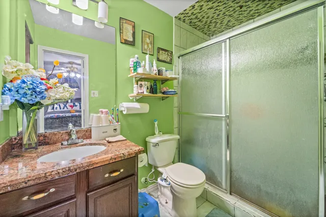 a bathroom with a granite countertop toilet sink and mirror