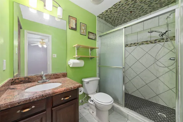 a bathroom with a granite countertop sink toilet and shower
