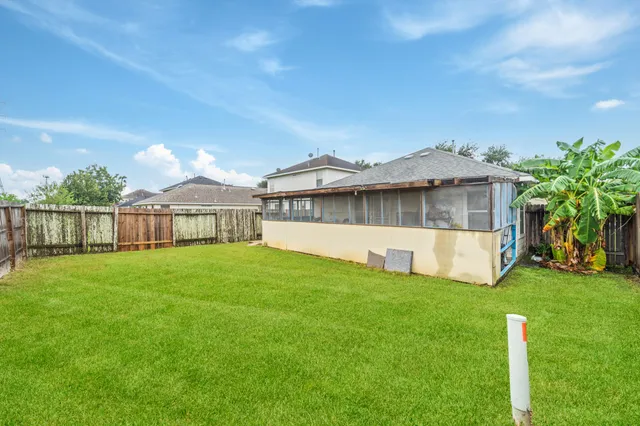 a view of a house with a big yard and a large tree