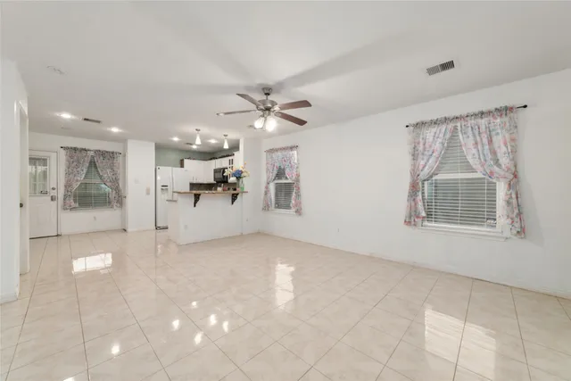 a view of a big room with windows and chandelier fan