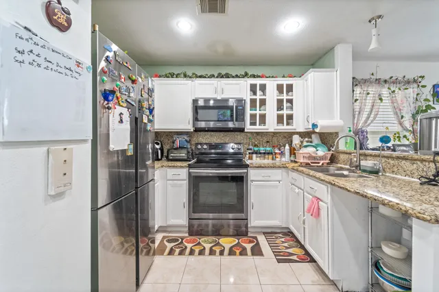 a kitchen with stainless steel appliances granite countertop a refrigerator and a stove