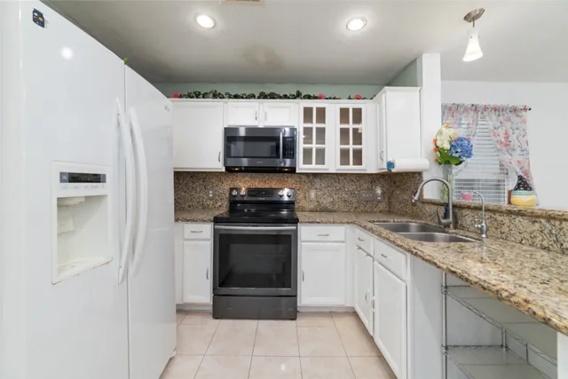 a kitchen with stainless steel appliances granite countertop a sink stove and microwave
