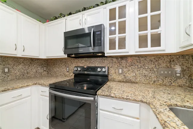 a kitchen with stainless steel appliances granite countertop a sink and a stove