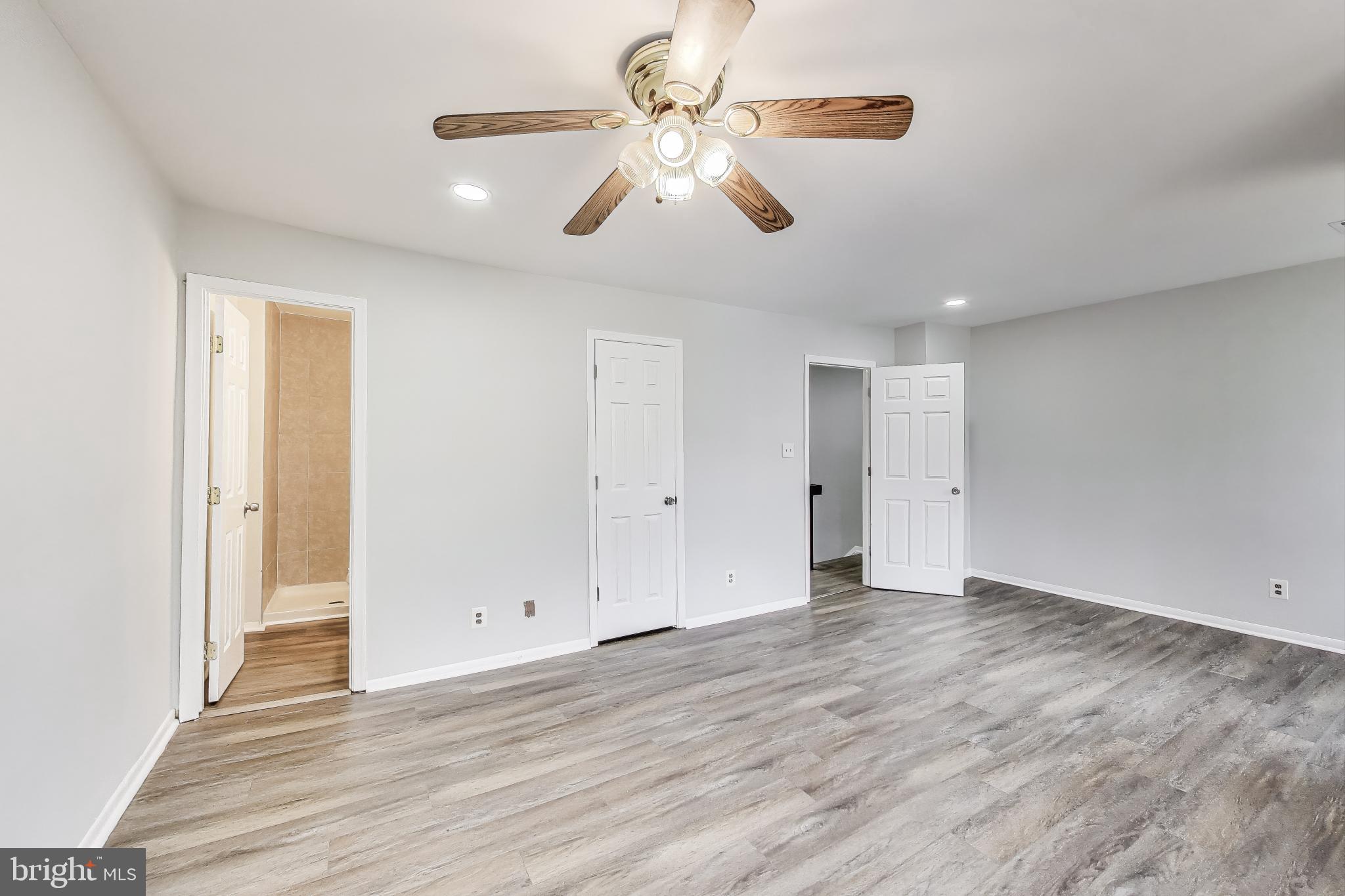 17520 Hoskinson Road Poolesville, MD 20837 - Photo 15 of 31 an empty room with wooden floor chandelier fan and windows