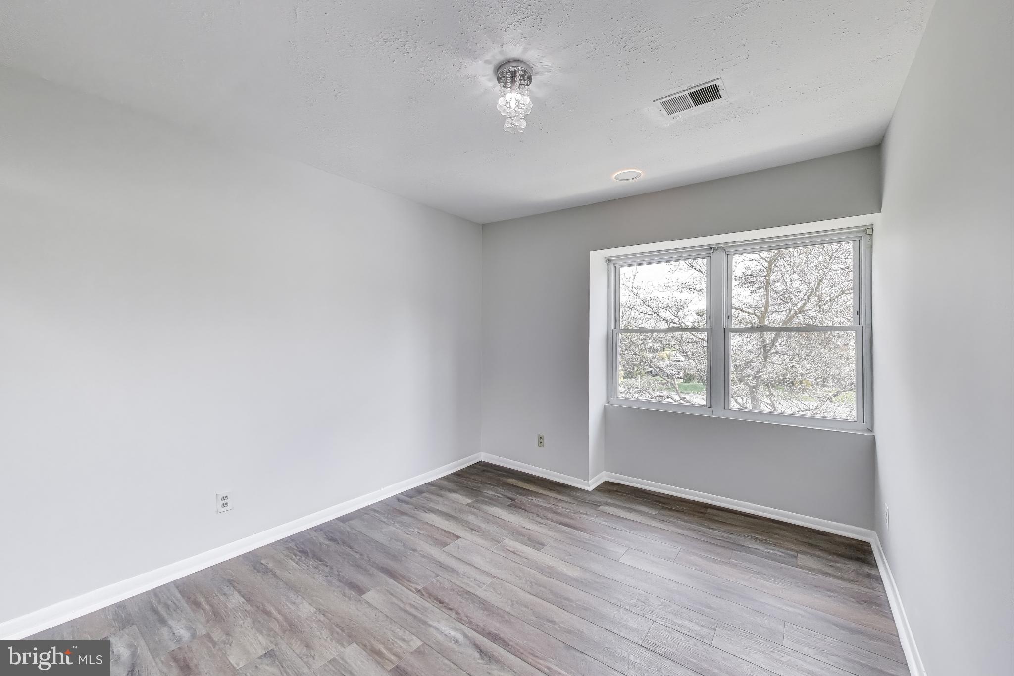 17520 Hoskinson Road Poolesville, MD 20837 - Photo 18 of 31 an empty room with wooden floor and windows