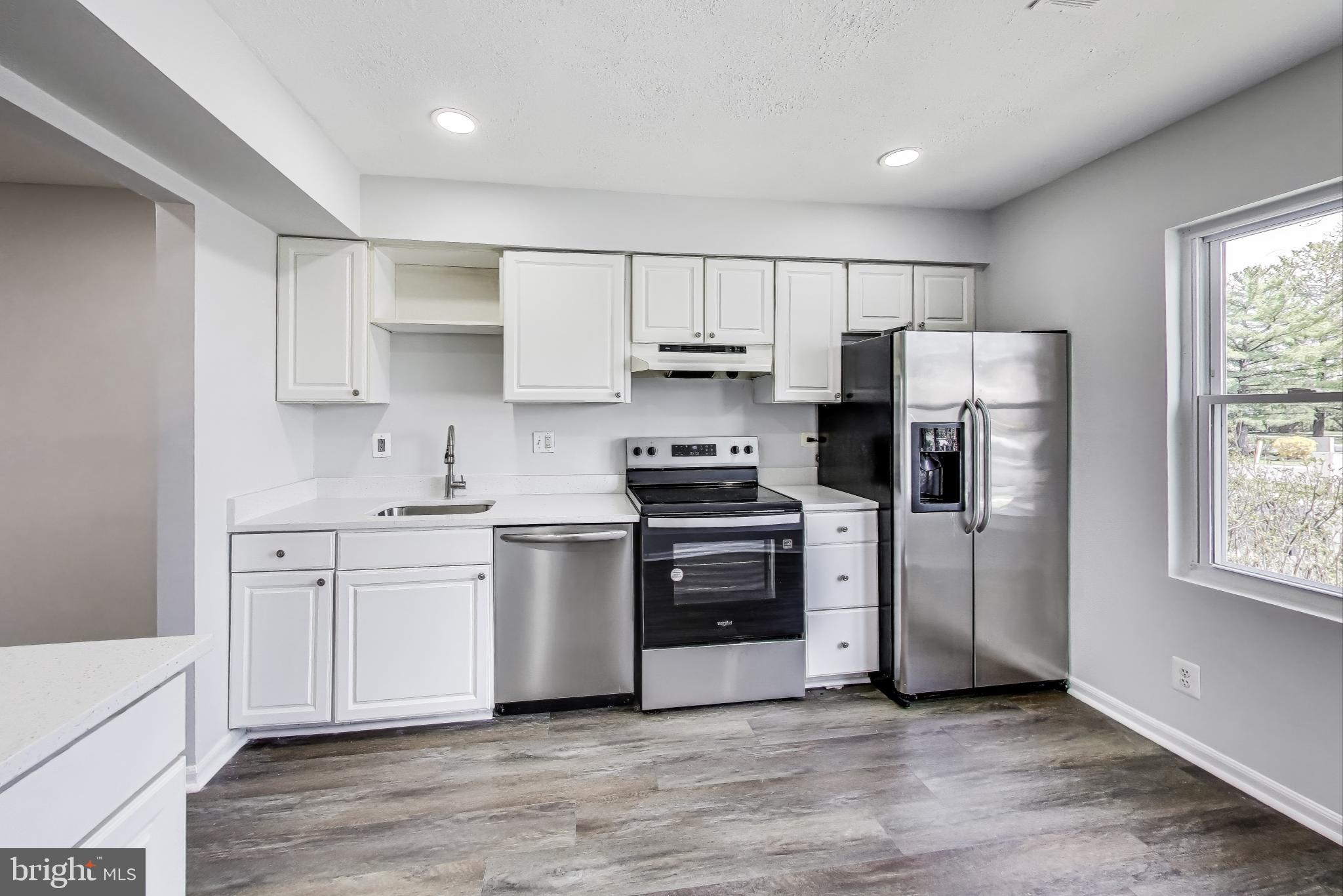 17520 Hoskinson Road Poolesville, MD 20837 - Photo 2 of 31 a kitchen with white cabinets stainless steel appliances and a window