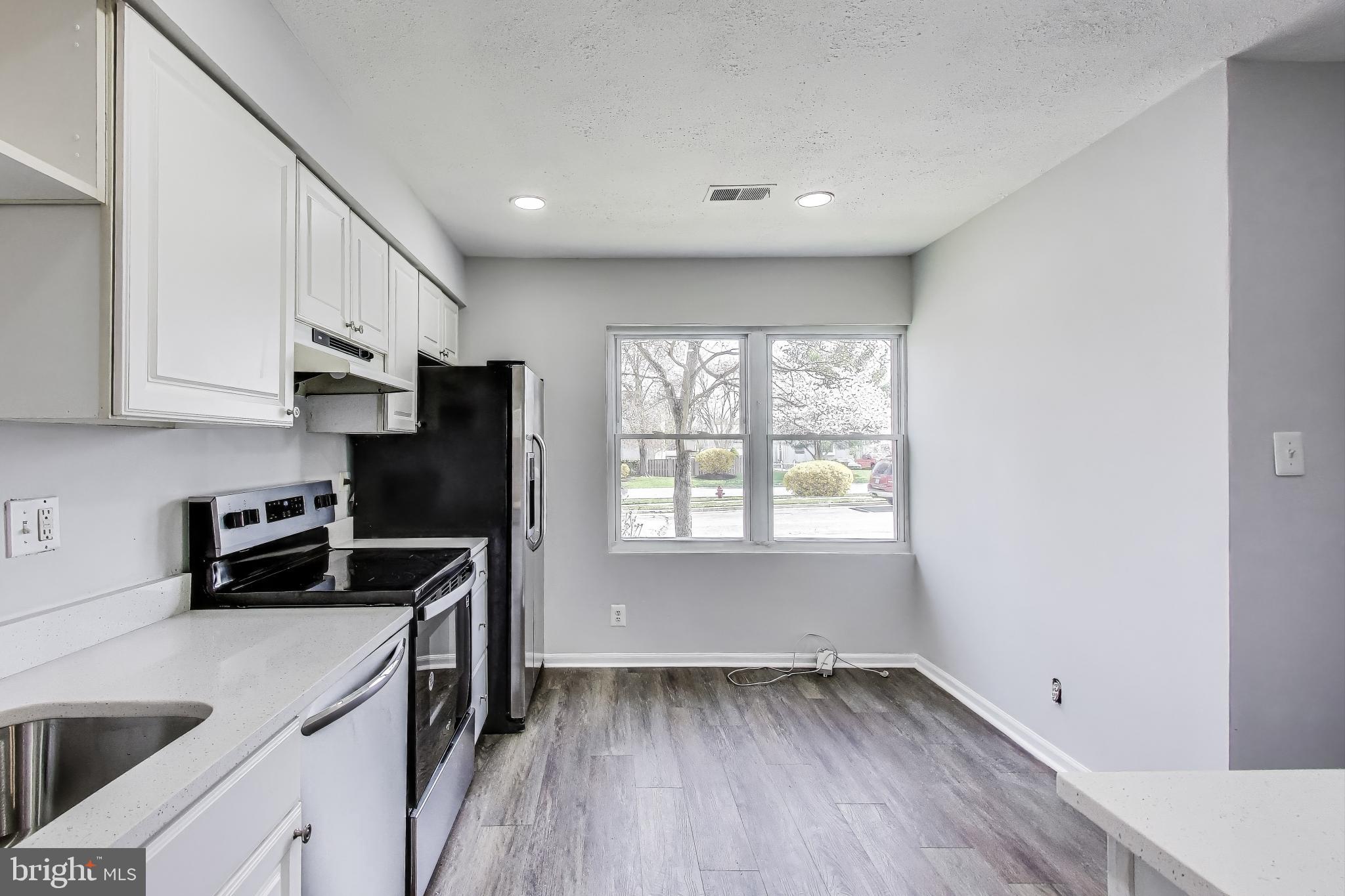 17520 Hoskinson Road Poolesville, MD 20837 - Photo 3 of 31 a kitchen with a sink a refrigerator and window