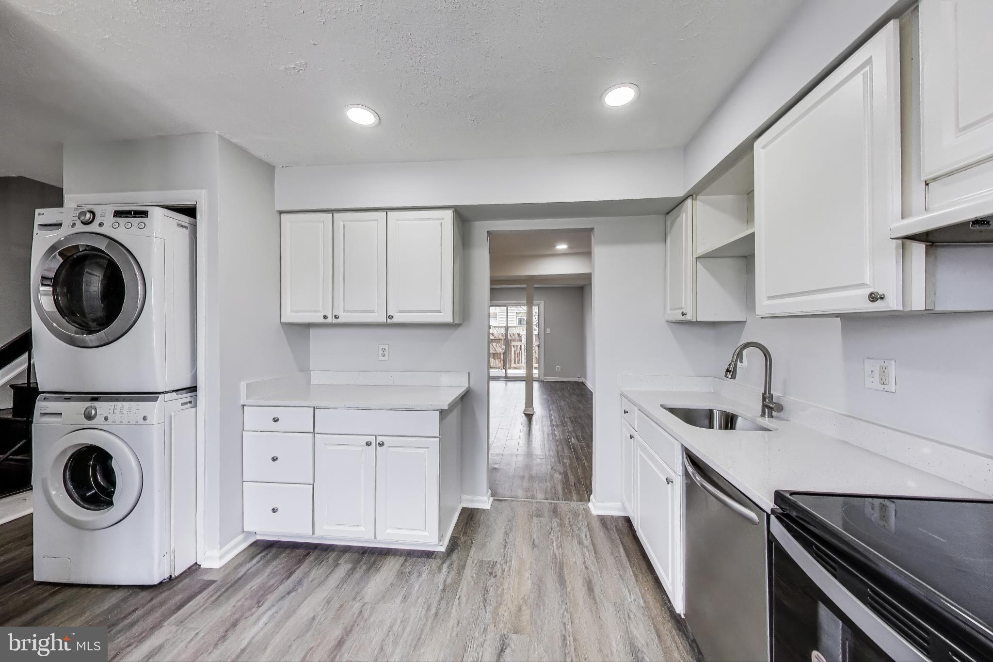 17520 Hoskinson Road Poolesville, MD 20837 - Photo 4 of 31 a kitchen with a sink a washer and dryer with wooden floor