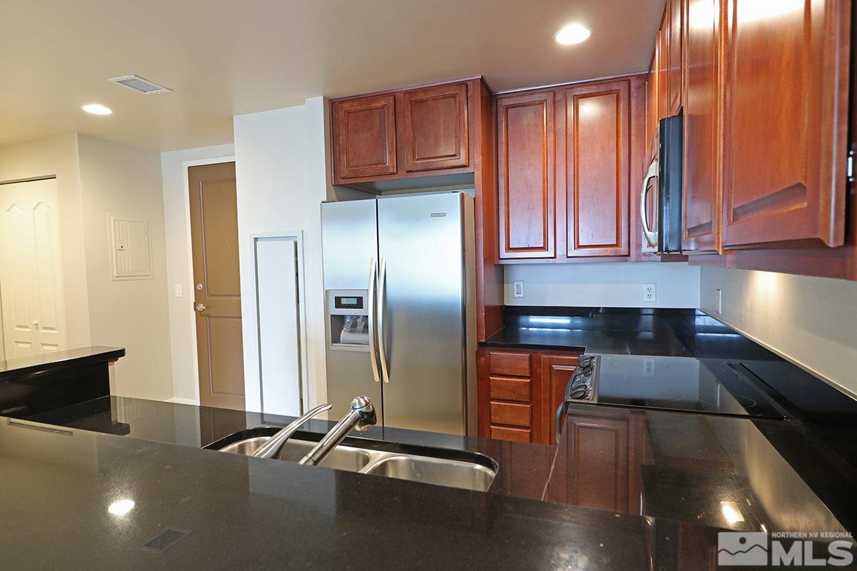 50 North Sierra Street, Unit 706 Reno, NV 89501 - Photo 2 of 24 an open kitchen with stainless steel appliances granite countertop a refrigerator and a sink