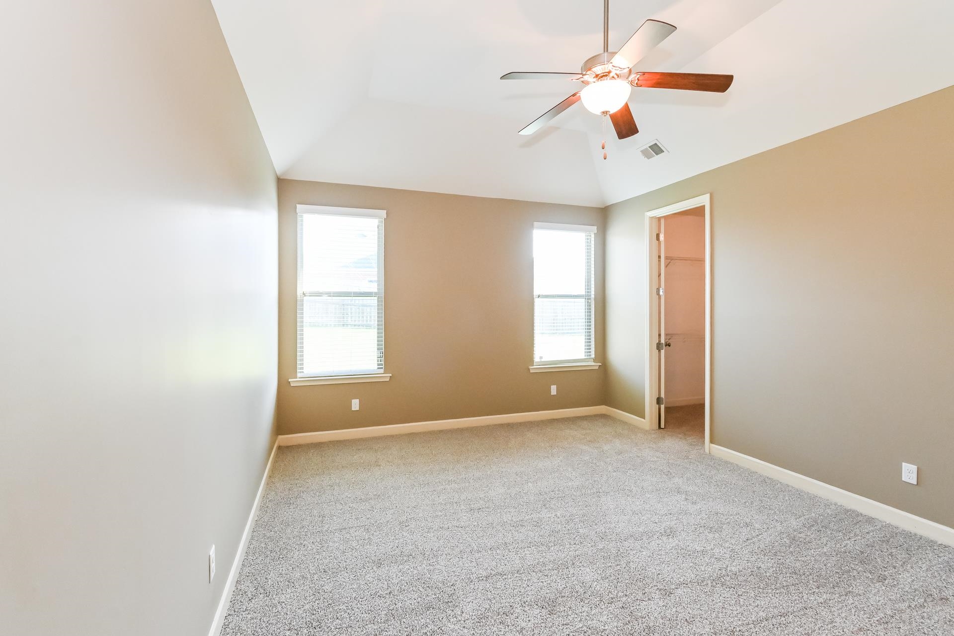 7530 Bevy Ridge Lane Memphis, TN 38125 - Photo 11 of 22 Unfurnished room featuring ceiling fan, vaulted ceiling, and light colored carpet