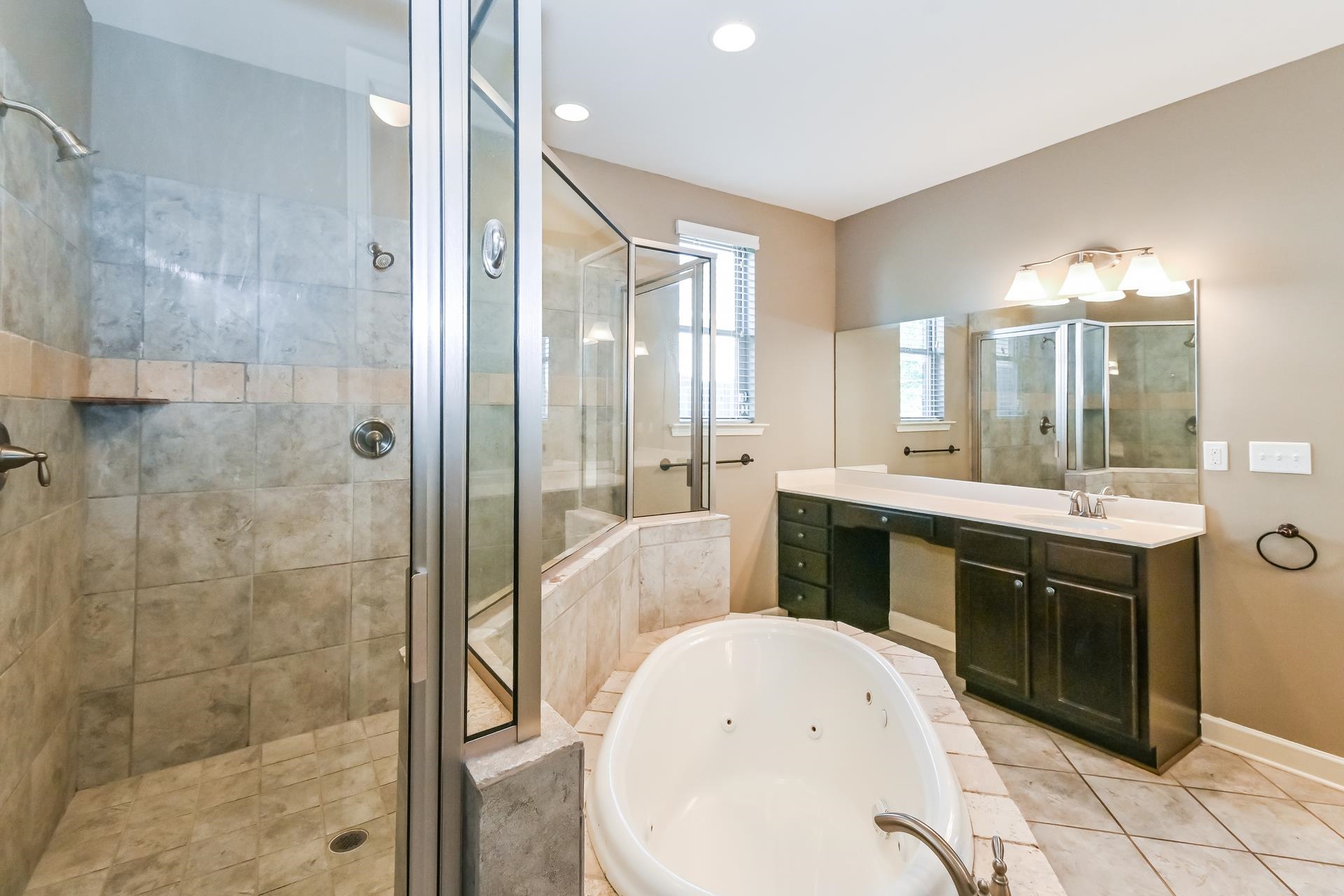 7530 Bevy Ridge Lane Memphis, TN 38125 - Photo 13 of 22 Bathroom with vanity with extensive cabinet space, tile floors, and plus walk in shower