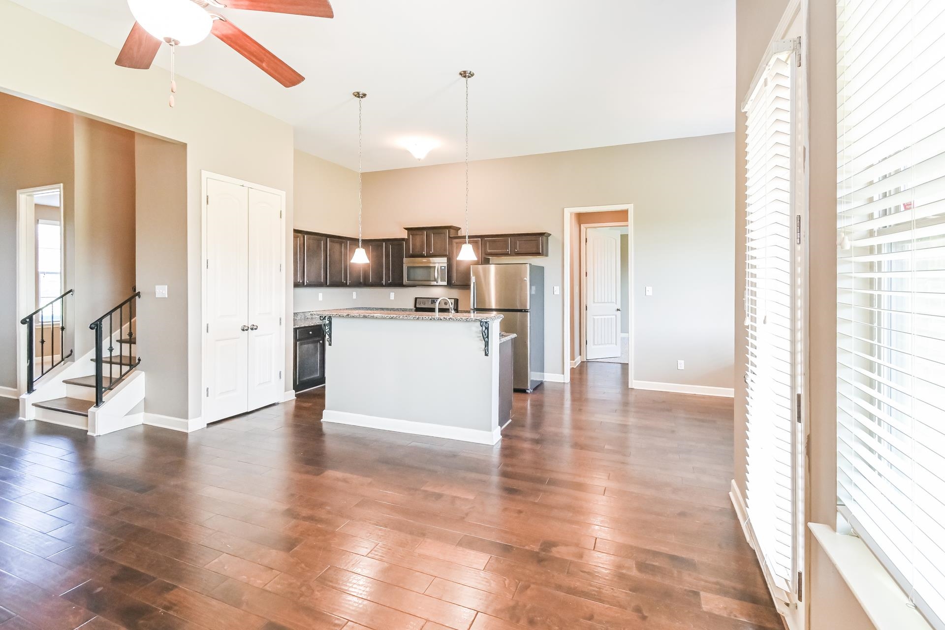 Kitchen featuring a center island, stainless steel appliances, dark hardwood / wood-style flooring, and decorative light fixtures