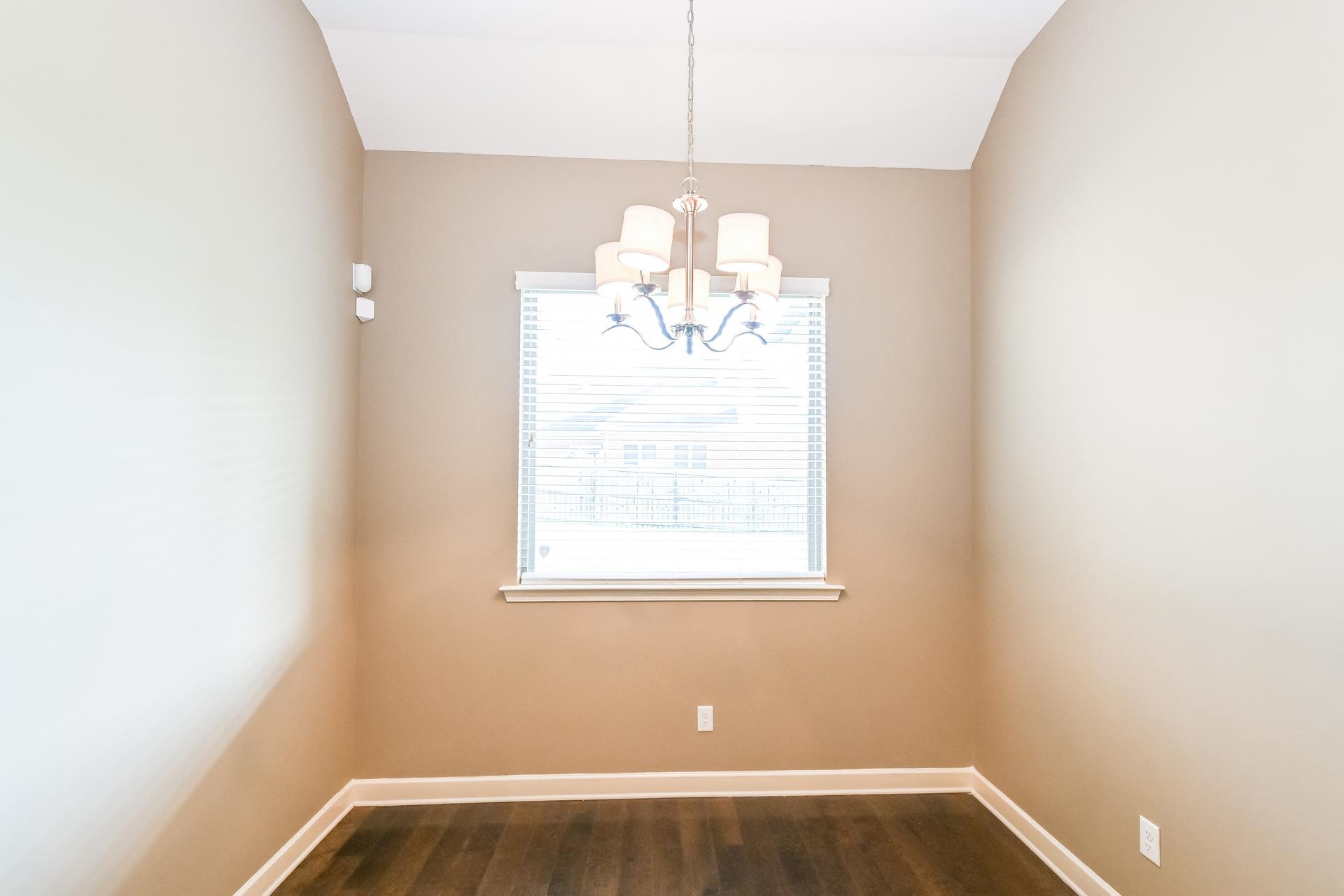 Unfurnished dining area with an inviting chandelier and wood-type flooring