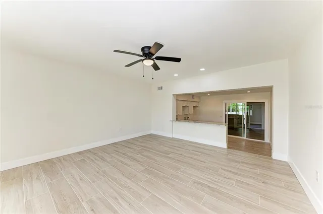 a kitchen with white cabinets and wooden floor